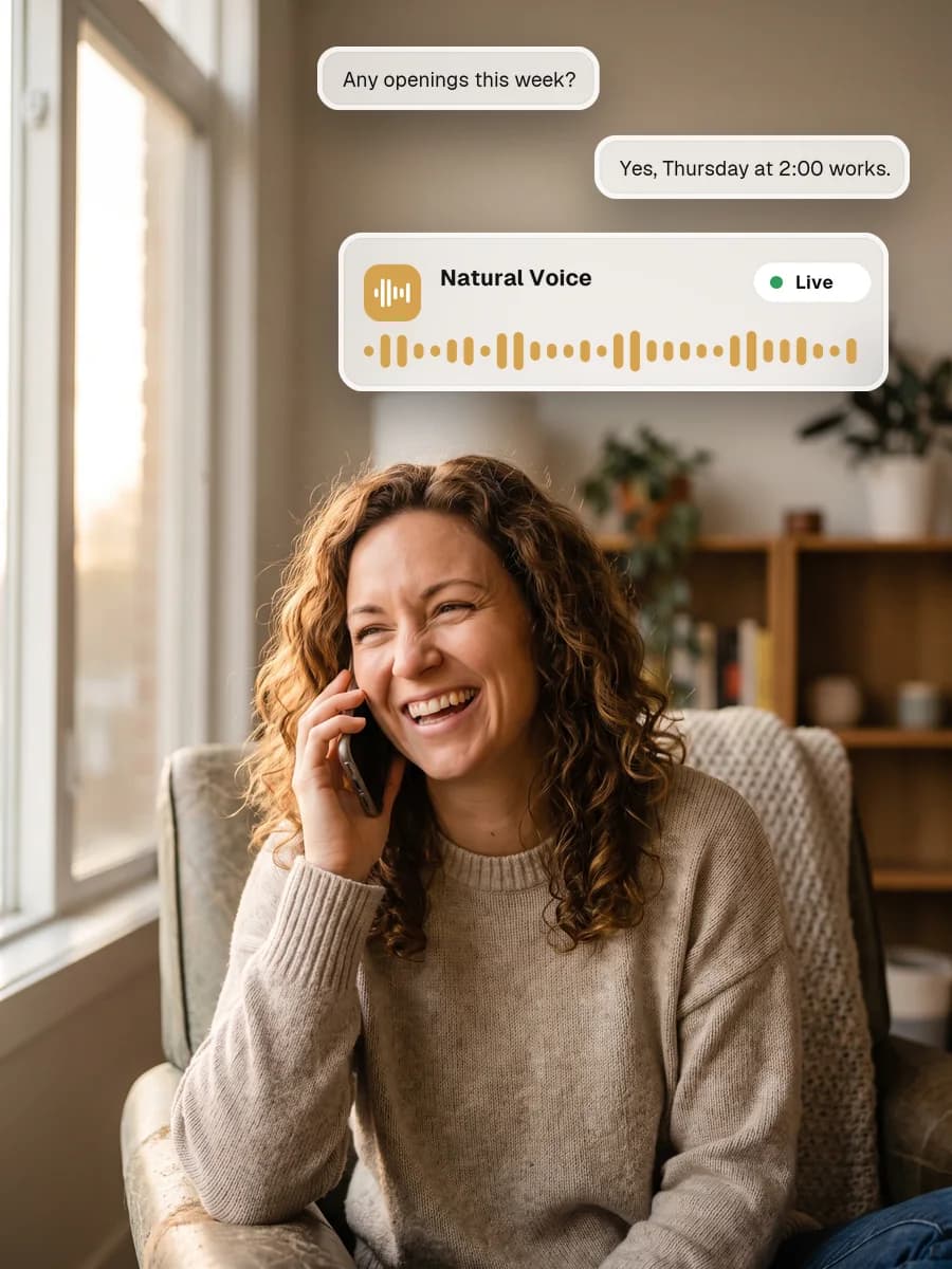 A woman laughing warmly during a phone call at home